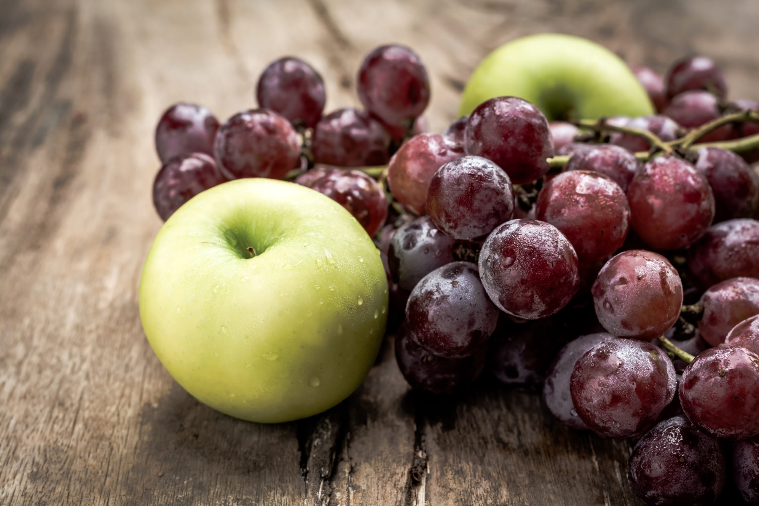 red grape with green apple on old wooden table